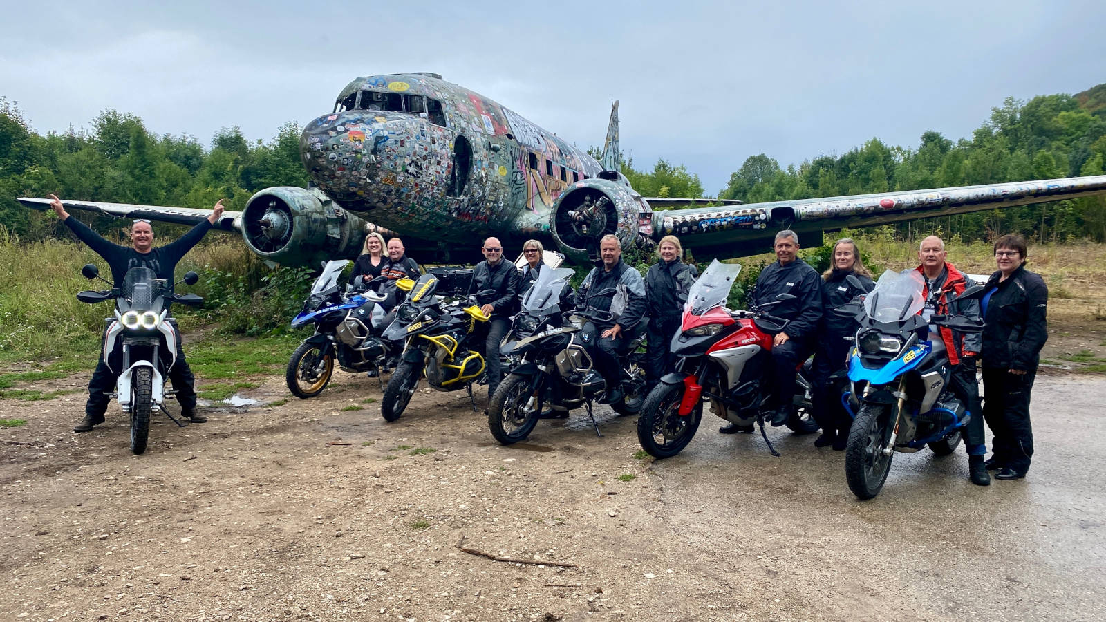 Motorcycle tour guys a front of aeroplane at Željava air base